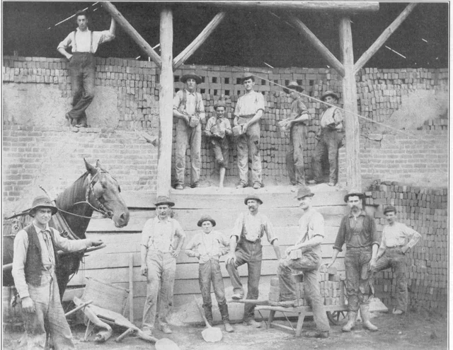 Historic black-and-white photograph of workers, stacked bricks, a horse, and equipment at a brick kiln in Tharptown
