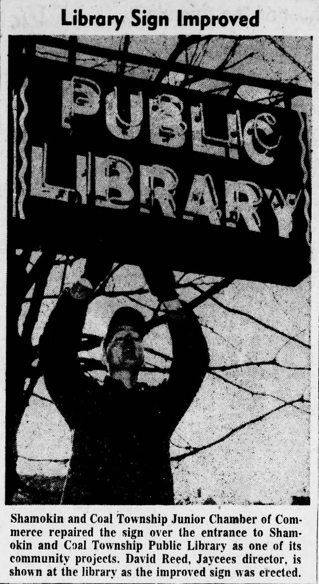 Man working beneath the repaired Public Library entrance sign in a 1958 Shamokin newspaper clipping